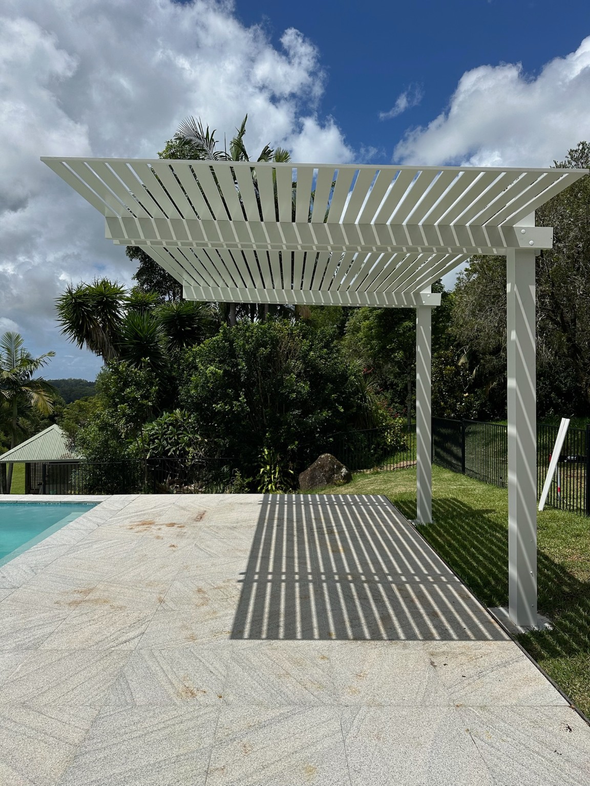 Open slat pergola casting patterned shade